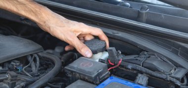 Adam motor fren sıvısını kontrol ediyor..