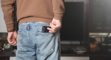 Kafkasyalı genç adam evde cüzdanını gösteriyor..