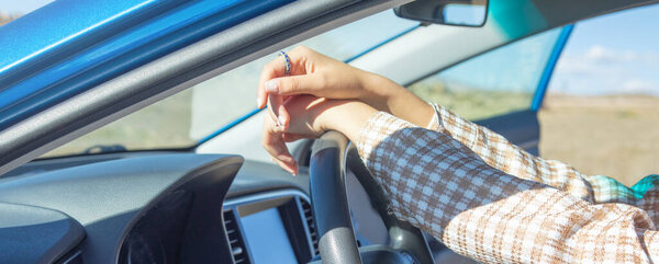 Female hands in steering wheel of car