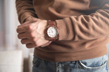 Kafkasyalı genç adam evde kol saati takıyor..