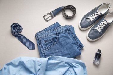 Kemerli mavi kot pantolon ve gri arka plandaki diğer nesneler..