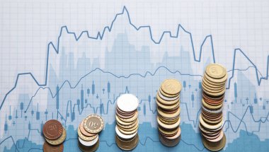 Finansal büyüme grafiklerine sahip bozuk para yığını.