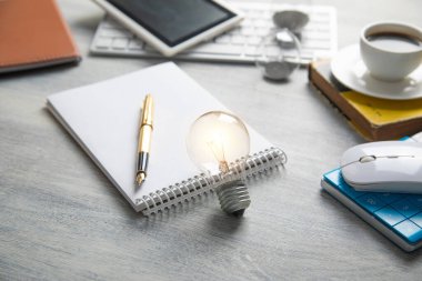 Masada iş objeleri olan bir ampul.