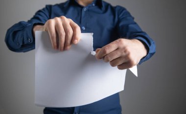 İşadamı ofiste sözleşmeyi yırtıyor.