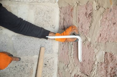 Kafkasyalı işçiler metal parçalarını duvara yapıştırmaya çalışıyor..