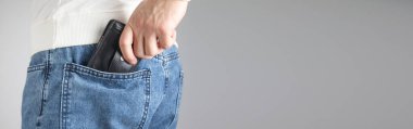 Cüzdanını pantolonunun cebine koyan adam..