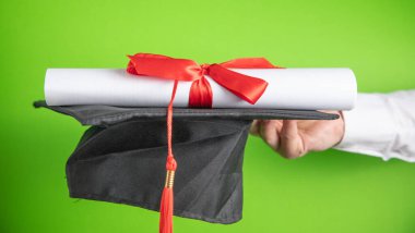 Mezuniyet şapkası ve diploması olan bir adam. Eğitim