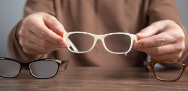 Kafkasyalı teknisyen farklı gözlükler tutuyor..