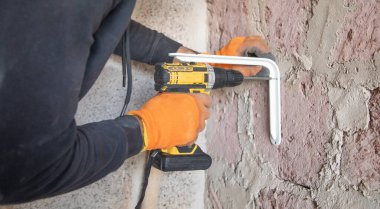 Beyaz işçi elektrikli matkap kullanıyor..