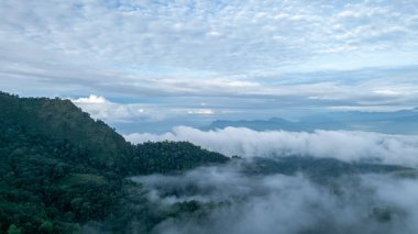 Sis kaplı tepelerin sakin ve sisli bir manzarayla sakin ve atmosferik bir ruh halini çağrıştıran sakin bir drone görüntüsü. Doğa ve sükunet temalı projeler için ideal.