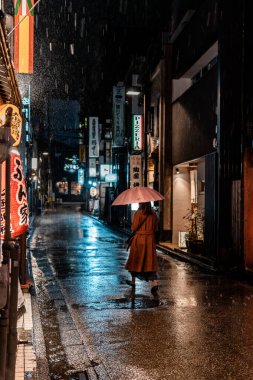 Kanazawa, Japonya - 19 Kasım 2023: Yağmurlu Japon Sokak 'ında Gece Yürüyen Kadın