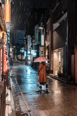 Kanazawa, Japonya - 19 Kasım 2023: Yağmurlu Japon Sokak 'ında Gece Yürüyen Kadın