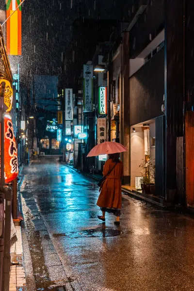Kanazawa, Japonya - 19 Kasım 2023: Yağmurlu Japon Sokak 'ında Gece Yürüyen Kadın