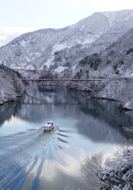 Kışın Shogawa Nehri 'nde karla kaplı manzaralar ve sakin sularla çevrili manzaralı bir tekne gezisi..