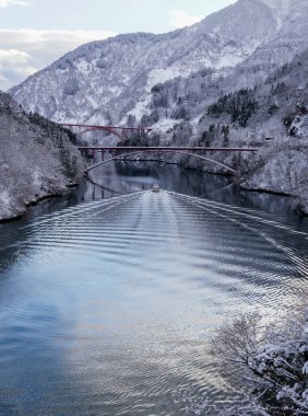 Kışın Shogawa Nehri 'nde karla kaplı manzaralar ve sakin sularla çevrili manzaralı bir tekne gezisi..
