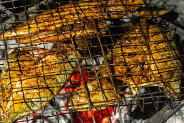 Terbiye edilmiş balık, üstünde limon dilimleri olan sıcak kömürün üstünde ızgara. Otantik barbekü deniz ürünleri hazırlama, aşçılık, geleneksel yemekler ve yaz barbekü temaları için mükemmel..