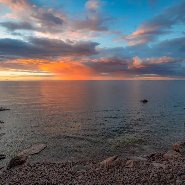 Bulutlu bir gökyüzünde güzel bir günbatımının dikey görüntüsü.