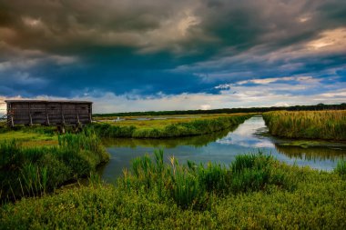 Bulutlu ve bulutlu bir göl manzarası.