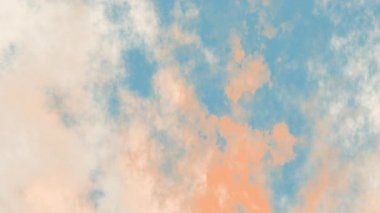 Mavi, beyaz ve şeftali rengi bulutların yumuşak bir karışımı ile rüya gibi bir gökyüzü. Renkler dingin ve ruhani bir atmosfer yaratıyor. Huzurlu bir doğal ortam yaratıyor. Sakinleştirici bir arka plan için mükemmel..