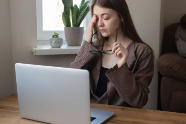Kadın ofis çalışanı, bilgisayar işinden bıkmış gözlüğünü çıkaran serbest çalışan. Baş ağrısı, göz yorgunluğu, konsantrasyon sorunları