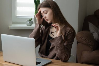 Kadın ofis çalışanı, bilgisayar işinden bıkmış gözlüğünü çıkaran serbest çalışan. Baş ağrısı, göz yorgunluğu, konsantrasyon sorunları