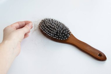 Saçları dökülmüş taraklı bir kadının eline yakın çekim. Saç dökülmesi sorunu, aşırı saç dökülmesi, saç dökülmesi....