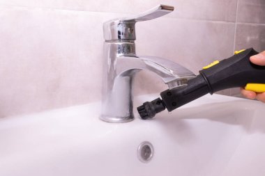 Banyo musluğunun etrafını kireç ve kiri temizlemek için buharla temizliyorum. Derin temizlik, banyo temizliği ve sağlık hizmetleri