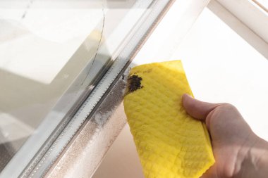 Kirli pencere çerçevesindeki toz ve kiri sarı bir paçavrayla temizleyin. Pencere temizleme