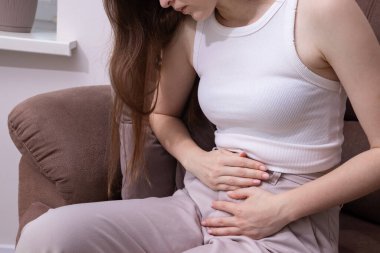 Karın ağrısı, periyod ağrısı, endometriyozis, adet sancıları, adet sancıları çeken bir kadın. Adet öncesi sağlık, kronik ağrı ve adet öncesi sendromu kavramı.