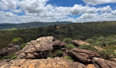Rock formation between mountains under cloudy sky