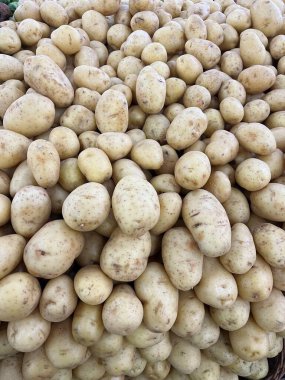 Vegetable display in supermarket, with potatoes stacked high