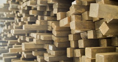 Ahşap tahtalar istiflenmiş ve marangozluk çerçevesinde düzenlenmiş. Sert ve kırsal ahşap, dokusu ve arka plan olarak güneş yüzüne vuruyor. Arka plan konsepti. Ahşap kavramı.