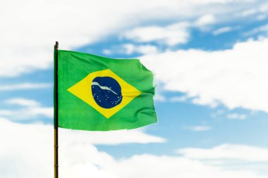 Arka planda mavi gökyüzü olan Brezilya bayrağı. Rüzgar hareketi. Metin için boşluk. Brezilya konsepti. Brezilya bayrağı konsepti