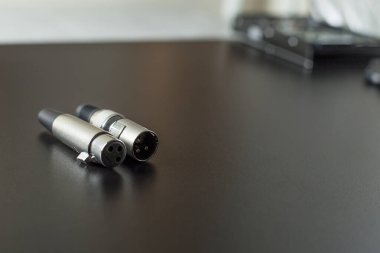 Siyah bir masanın üstündeki xlr ses kablosu. Bağlantılar ekranda. Kablolu yayın konsepti. ses kavramı.