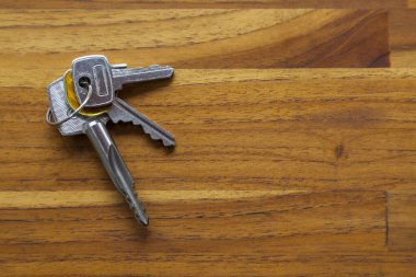 Evin kapısı, ahşap bir masanın üstünde. kopyalama alanı. Metin için boşluk. Anahtar konsept. Ev kavramı.