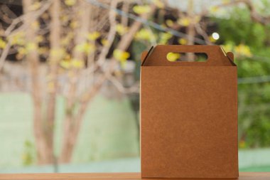 Arkasında sarı bir fiyonk ve çiçekler olan hediye paketi. Hediye konsepti. Sarı yay konsepti.