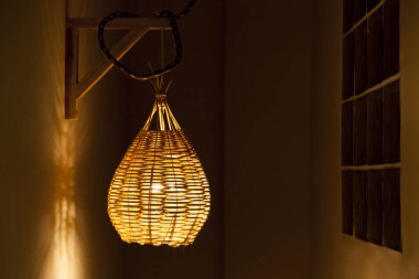 Açık hava bölgesi için sarı ışıklı kolye. Samandan yapılmış el yapımı lamba. Luminaire konsepti. Evim evim güzel evim.