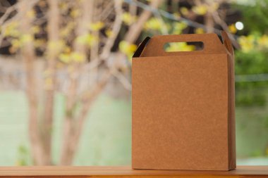 Arkasında sarı bir fiyonk ve çiçekler olan hediye paketi. Hediye konsepti. Sarı yay konsepti.