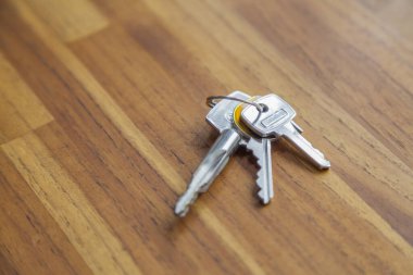 Evin kapısı, ahşap bir masanın üstünde. kopyalama alanı. Metin için boşluk. Anahtar konsept. Ev kavramı.