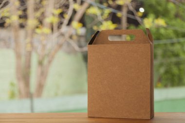 Arkasında sarı bir fiyonk ve çiçekler olan hediye paketi. Hediye konsepti. Sarı yay konsepti.