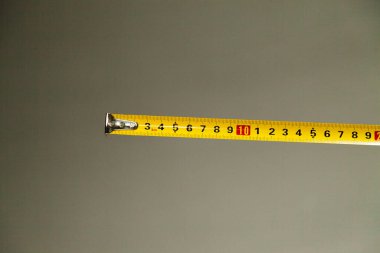 Tarafsız arkaplanda sarı santimetre mezurası. Şerit konseptini ölçüyorum. Ölçüm kavramı.