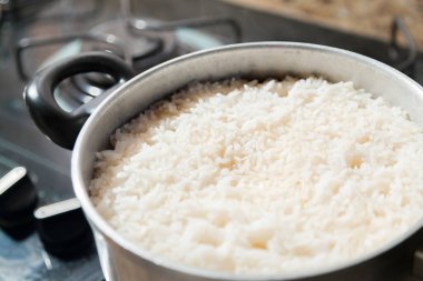 Fırının üstünde şömineyi yakan pilav pişiricisi. Pirinç kavramı. Yiyecek konsepti.