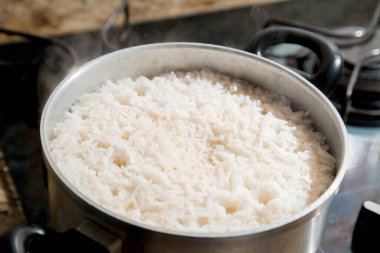 Fırının üstünde şömineyi yakan pilav pişiricisi. Pirinç kavramı. Yiyecek konsepti.