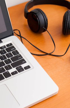 Kulaklıklı bir defter masanın üstünde. Podcast. Akıyor. Not defteri konsepti. Kulaklık konsepti.