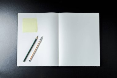 Kırtasiye aksesuarlarıyla boş defterleri aç. Üst Manzara. Notlar gönder. Gülümse. Boş defter konsepti. Gülme konsepti.