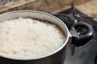 Fırının üstünde şömineyi yakan pilav pişiricisi. Pirinç kavramı. Yiyecek konsepti.