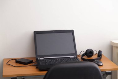 Kulaklıklı bir defter masanın üstünde. Podcast. Akıyor. Not defteri konsepti. Kulaklık konsepti.