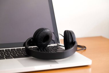 Kulaklıklı bir defter masanın üstünde. Podcast. Akıyor. Not defteri konsepti. Kulaklık konsepti.