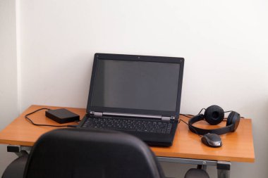 Kulaklıklı bir defter masanın üstünde. Podcast. Akıyor. Not defteri konsepti. Kulaklık konsepti.