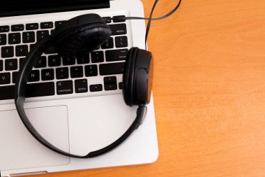 Kulaklıklı bir defter masanın üstünde. Podcast. Akıyor. Not defteri konsepti. Kulaklık konsepti.